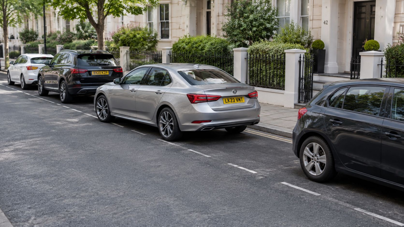 A silver car parked on a London residential street among other vehicles parked along the curb.